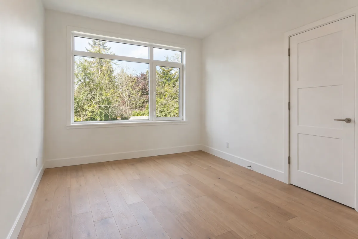 A small empty spare room with one large window